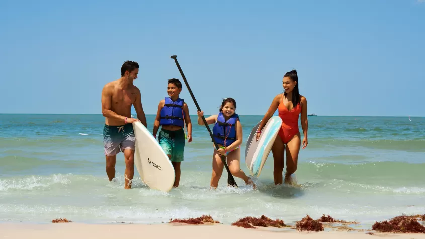 family paddle boarding in ocean