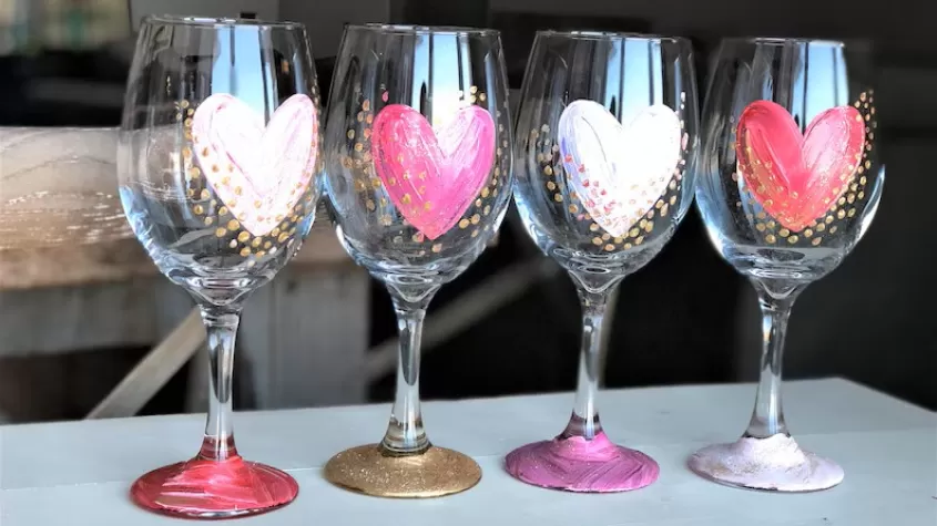 four wine glasses with pink, white and red hearts pained on them